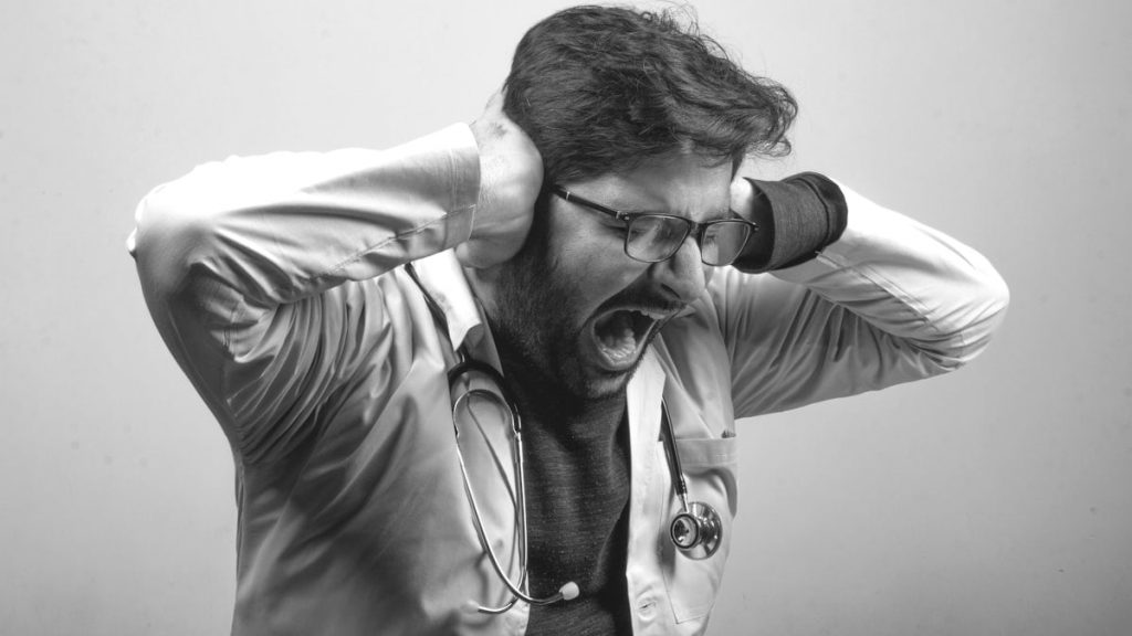 A doctor stressed frustrated at work freaking out  - Black and White