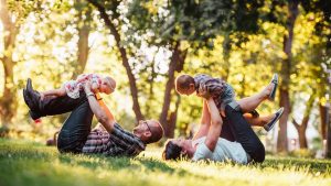 A joyful family enjoying playtime in a sunny park, capturing moments of laughter and happiness.